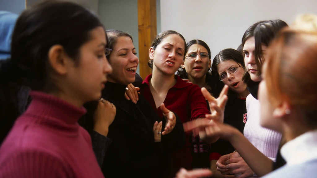 Global Peacebuilder Network - Eight younger women in a circle discussing with each other